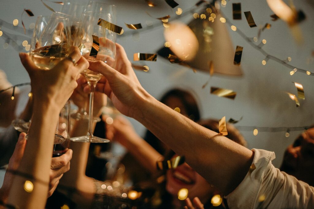 people putting their wine glasses together to celebrate