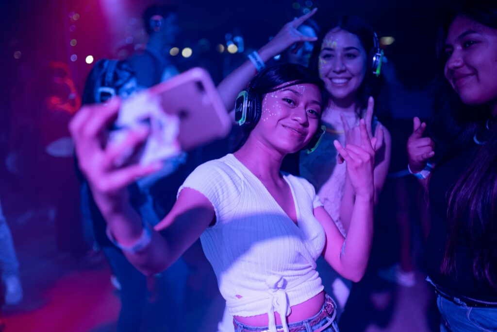 Drei Personen machen während einer Party ein Selfie